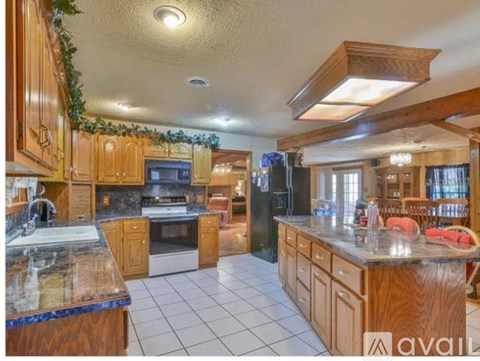 A kitchen with wooden cabinets and a marble countertop.