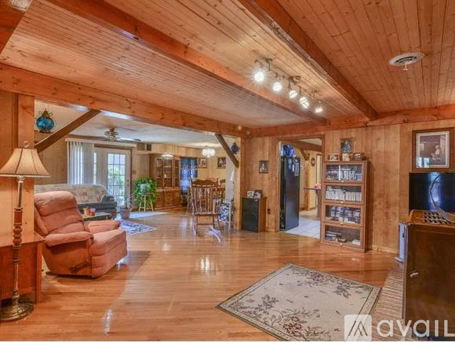 A living room with wooden walls and a high ceiling.