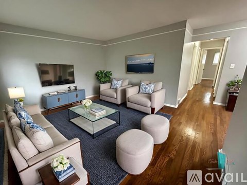 A living room with a glass coffee table and a blue rug.