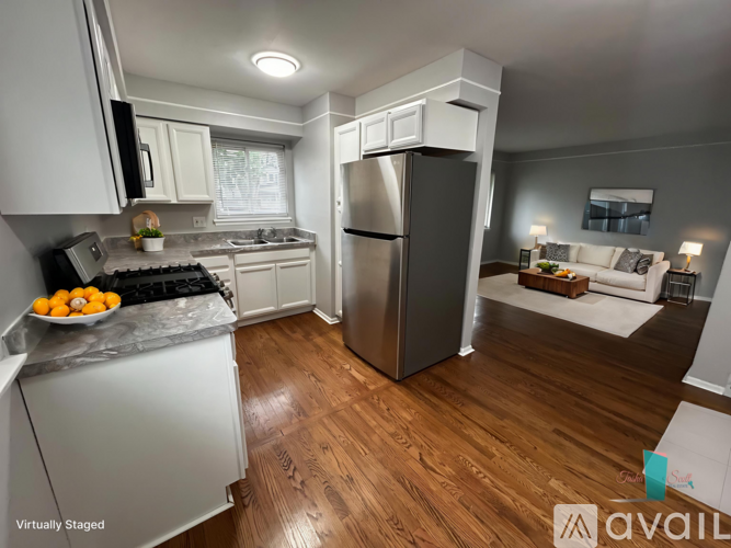 A kitchen with a refrigerator, stove, and sink.