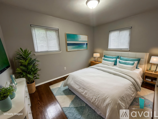 A bedroom with a large bed and a painting on the wall.