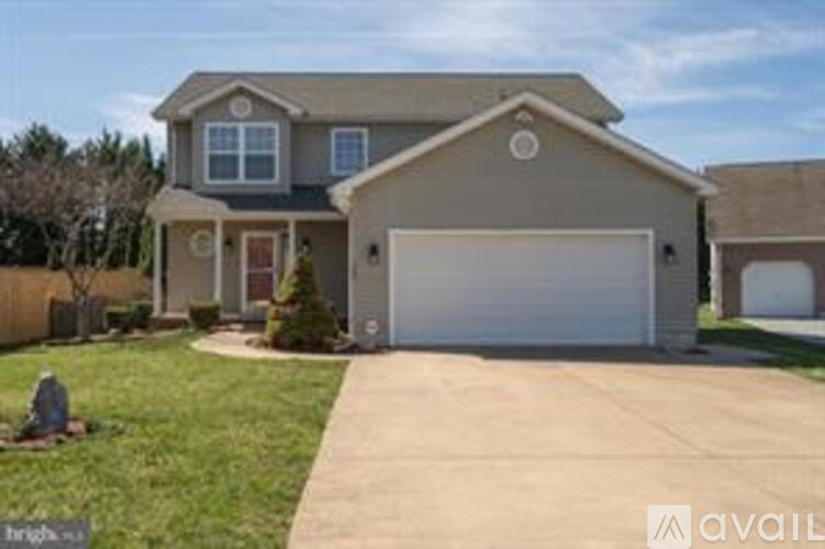 A house with a garage and a driveway is available for sale.