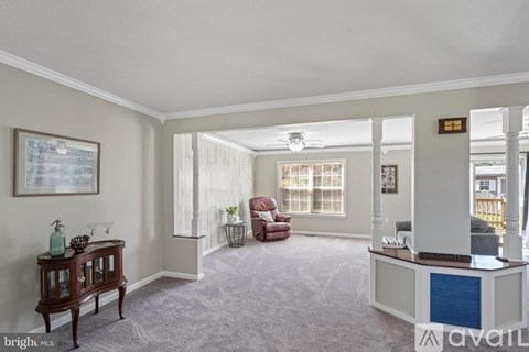A living room with a red chair and a wooden table.