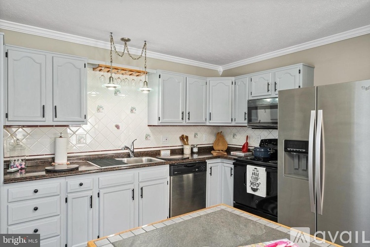 A kitchen with white cabinets and a black stove top oven.