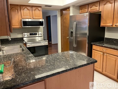 A kitchen with wooden cabinets and granite countertops.