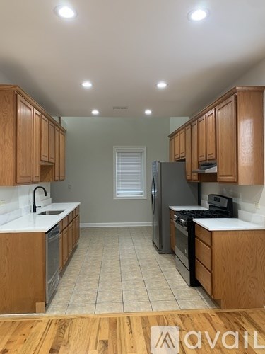 A kitchen with wooden cabinets and a tiled floor.