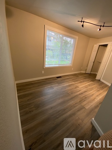 A room with wooden flooring and a window.