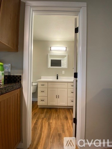 A small kitchen with white cabinets and a microwave above the stove.