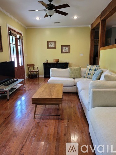 A living room with a white couch and a wooden coffee table.