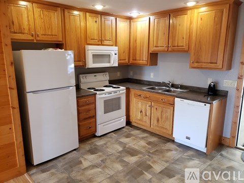 A kitchen with wooden cabinets and a white refrigerator.
