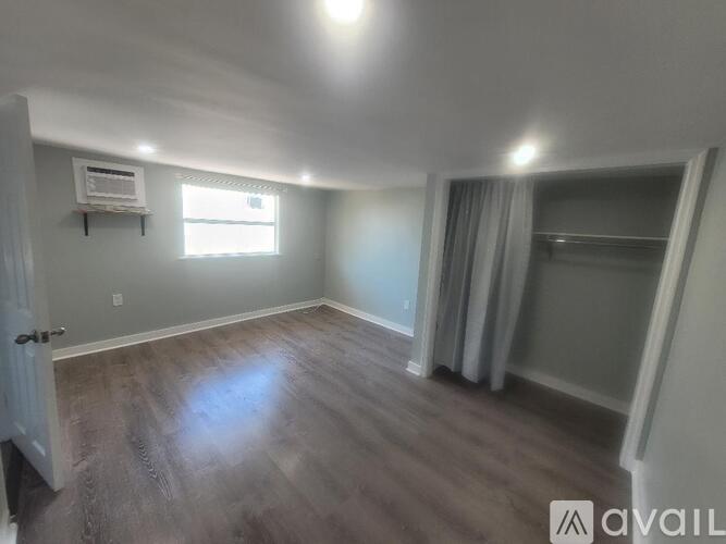 A room with wooden flooring and a window.
