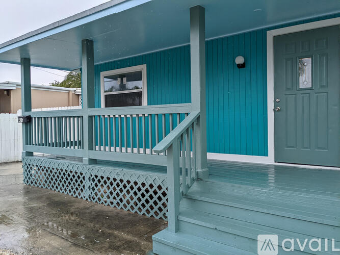 A blue house with a porch and a door.