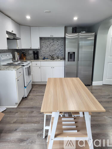 A kitchen with a table and stairs leading to a second floor.