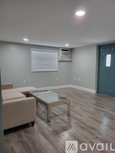 A living room with a beige couch and a glass coffee table.
