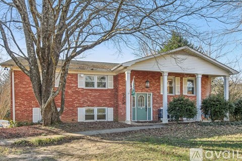 A red brick house with a green door and white trim.