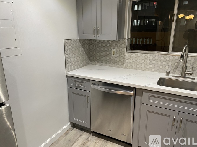 A kitchen with a stainless steel refrigerator and a white countertop.