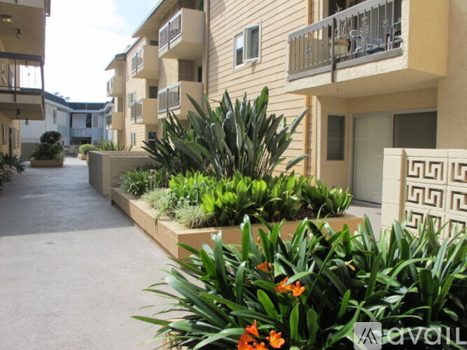 A row of apartment buildings with a landscaped garden in front.