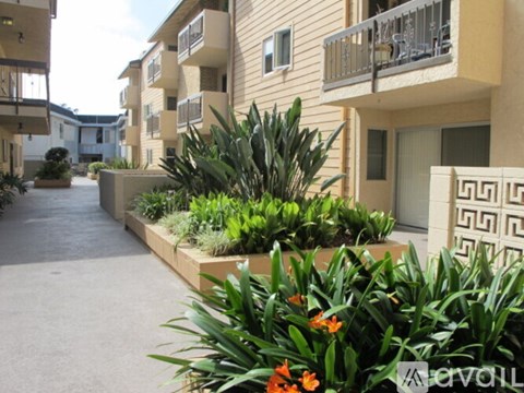 A row of apartment buildings with a landscaped garden in front.
