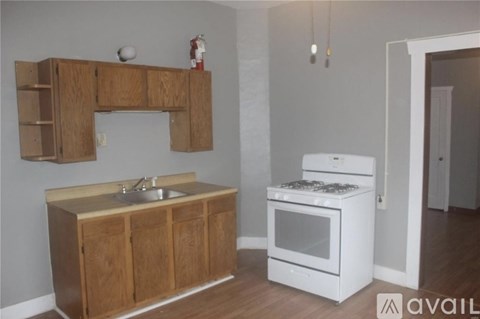 A kitchen with a white oven and wooden cabinets.