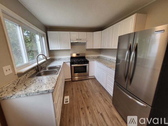 A kitchen with a granite countertop and stainless steel appliances.
