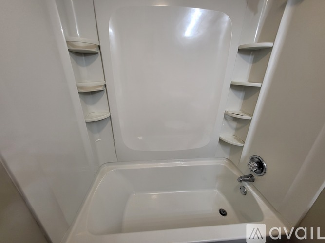 A white bathtub with a shower head and a faucet.