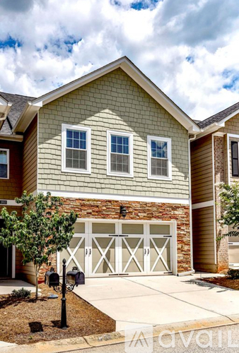 A house with a garage door and a brick wall.