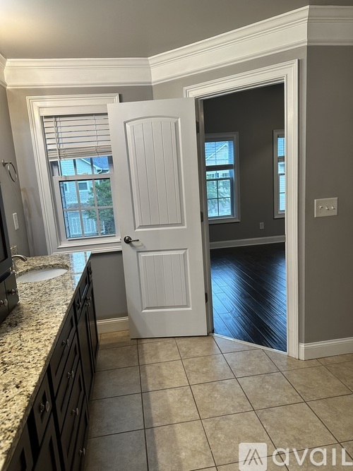 A kitchen with a white door and a window.