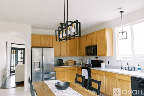 A kitchen with wooden cabinets and a black bowl on the counter.