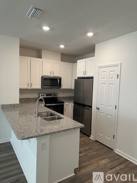 A kitchen with granite countertops and white cabinets.