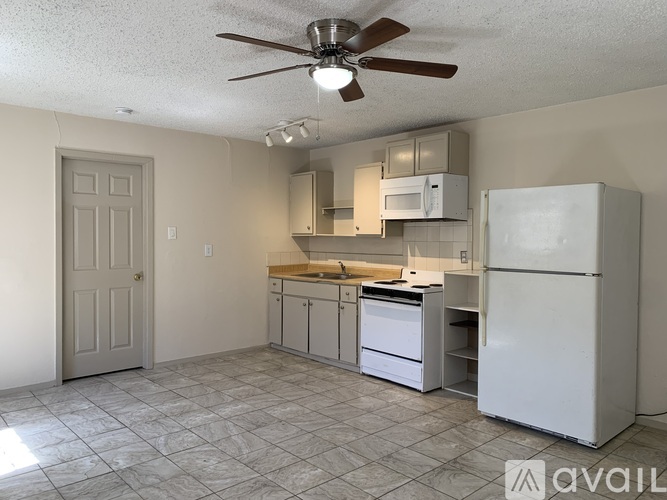 A kitchen with a white refrigerator, microwave, and dishwasher.