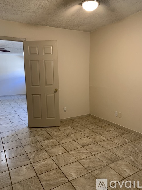 A room with a tile floor and a door leading to a hallway.