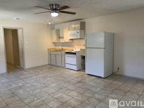 A kitchen with a white refrigerator, white cabinets, and a white stove top oven.