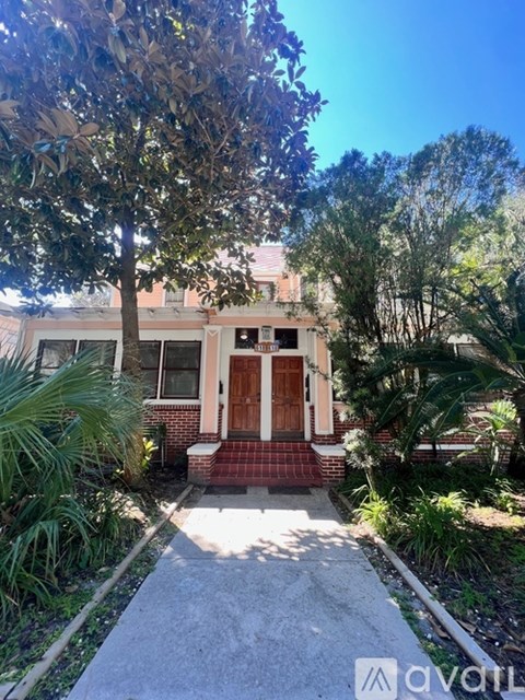 A house with a red door and a tree in front.