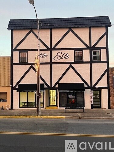 A black and white building with a sign that says "The Elk".