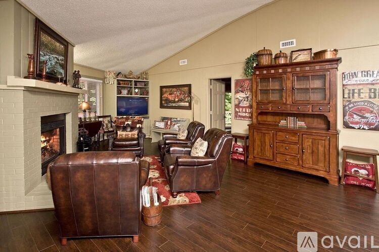 A living room with a fireplace and leather chairs.