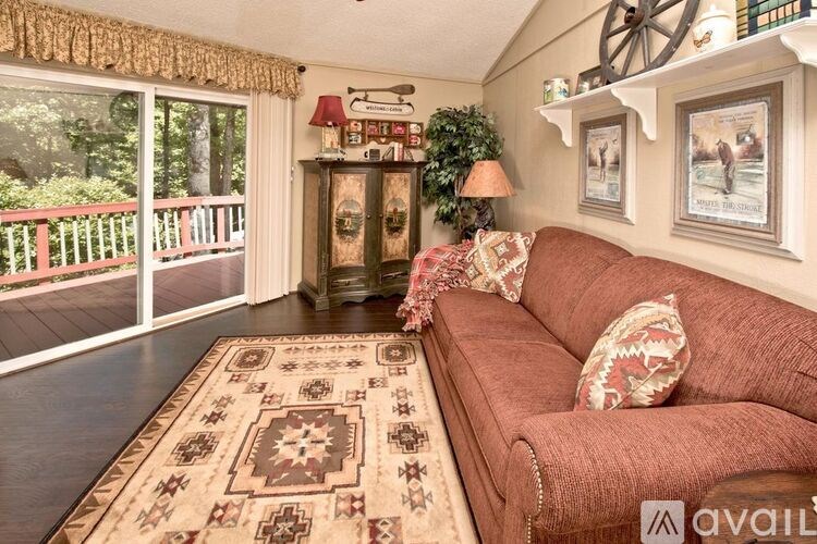 A living room with a red couch and a rug with a pattern on it.