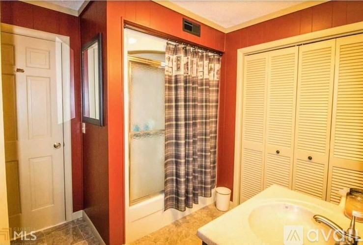 A bathroom with a sink, shower, and a toilet.