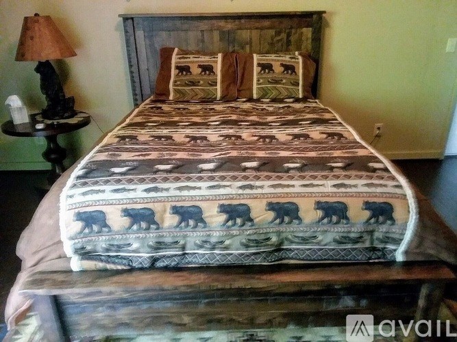 A bed with a dinosaur print is in the image.