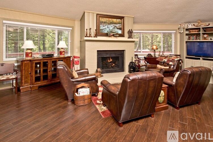 A living room with a fireplace and leather chairs.