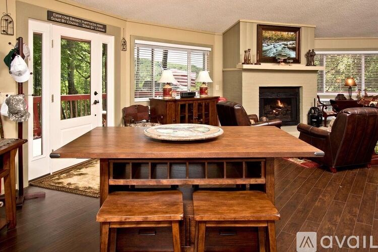 A living room with a fireplace and a dining table.