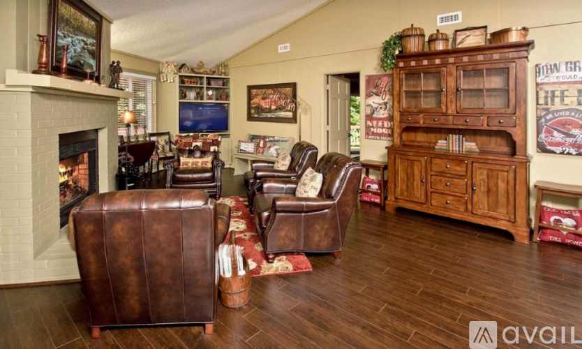 A living room with a fireplace and leather chairs.