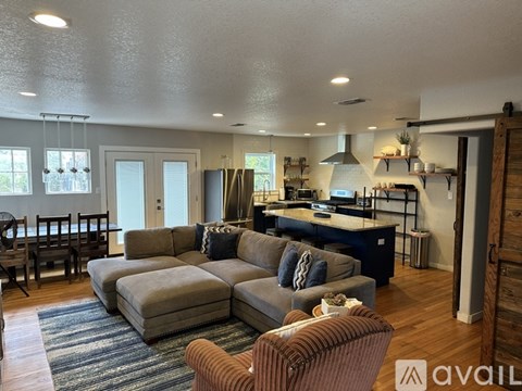 A living room with a grey couch and a brown chair.