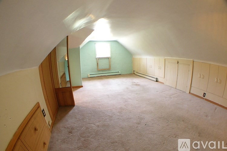 A room with a window and a carpeted floor.