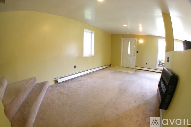 A living room with a couch and a window.