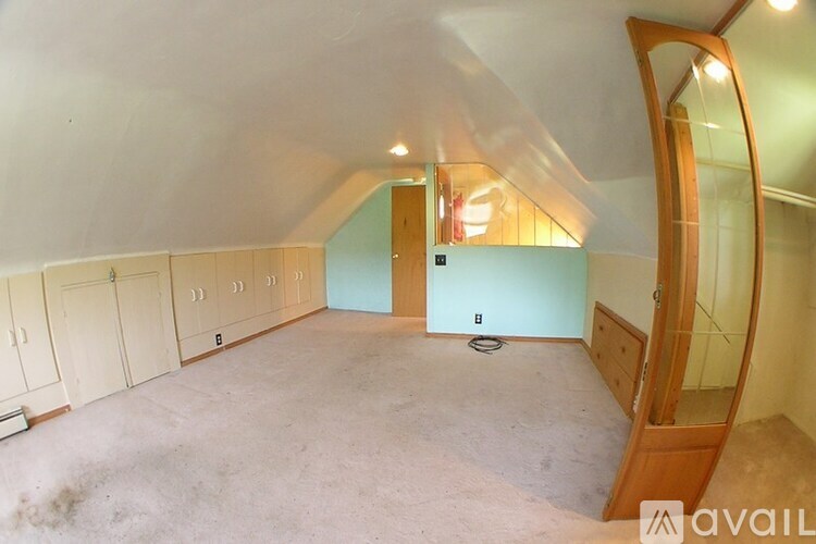 A room with a mirror on the right side and a door in the middle.