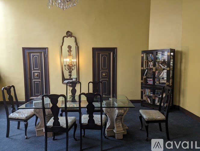 A room with a table, chairs and a chandelier.