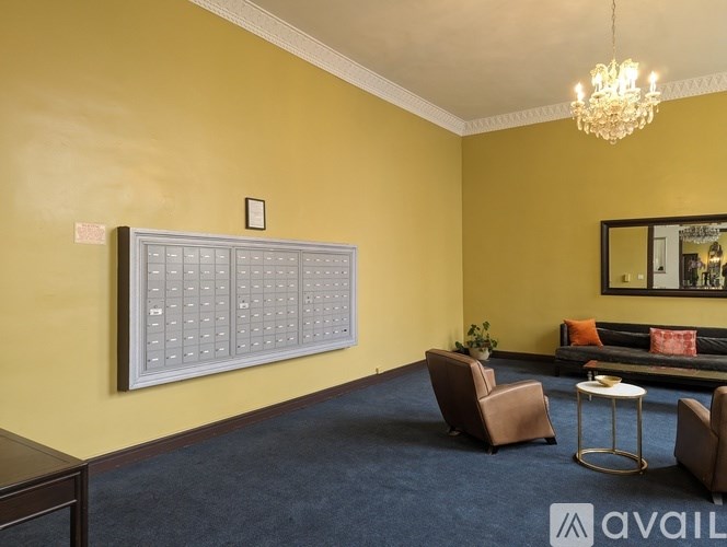 A room with a sofa, chairs, and a painting on the wall.