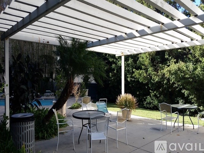 A patio with a table and chairs under a white canopy.