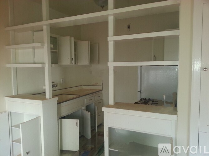 A kitchen with white cabinets and appliances is available for rent.