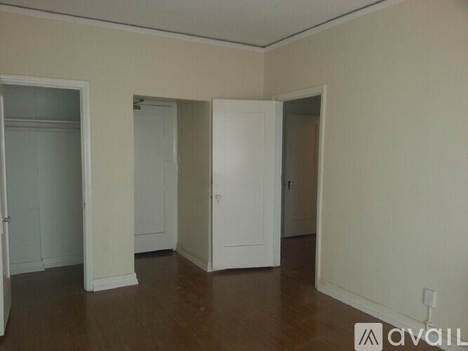 A room with white doors and a wooden floor.